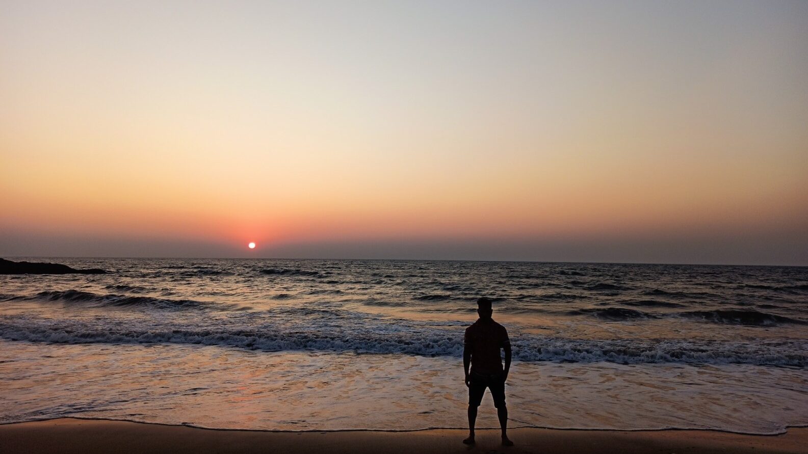 Breathtaking sunset on a Goa beach with golden sky, sea waves, and breeze