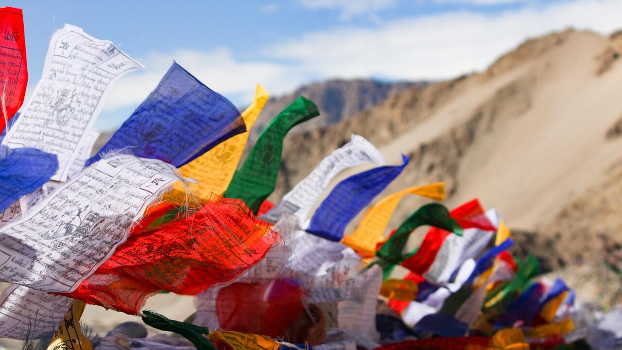 Vibrant Buddhist prayer flags fluttering in the wind, adding color to the serene landscape.