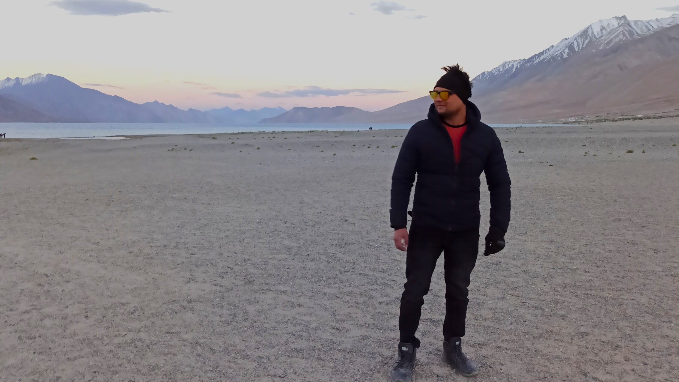 Solo rider geared up for Ladakh expedition, captured mid-journey with jerry cans and mountain backdrop